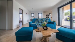 Un salon moderne avec un canapé, des poufs et une table basse.