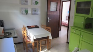 A dining area with a table, chairs, and a green cabinet. - in Cavalaire-sur-Mer by Interhome (Cavalaire)