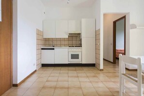 A compact kitchen with white cabinets, a stove, and a sink. - Stunning Family Retreat near Cinque Terre for 6 (Luni)