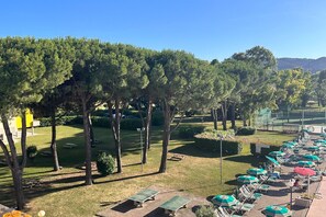 A courtyard with outdoor seating, a tennis court, and a row of umbrellas. - Stunning Family Retreat near Cinque Terre for 6 (Luni)