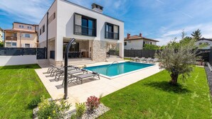 A modern two-story house with a swimming pool, outdoor seating, and a stone facade. - 6-Person Home with 3 En-Suites (Novigrad)