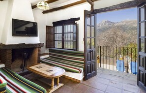 Ein gemütliches Zimmer mit Kamin, einer Bank und einem Fernseher.