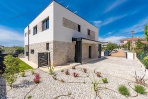 A modern two-story house with a stone facade, a black door, and a paved driveway. - Detached Holiday Villa for 6 (Novigrad)