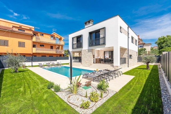 A modern two-story house with a swimming pool, a well-maintained lawn, and a stone wall. - Detached Holiday Villa for 6 (Novigrad)