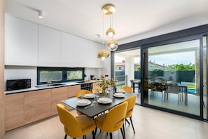 A modern kitchen with a dining area, large windows, and a view of the outdoors. - Detached Holiday Villa for 6 (Novigrad)
