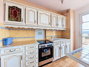 A kitchen with white cabinets, a stove, and a sink. - Hameau la Madrague by Interhome (Saint Cyr sur Mer La Madrague)