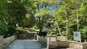 A gated entrance with stone walls, a metal gate, and a sign indicating a Landfitz property. - Landsitz Kammerburg - Verwalterwohnhaus (Lorch)