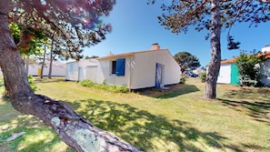 A small, single-story building with a sloped roof, a door, and a window with blue shutters. - Bois Marin - Pool & Beach 500 meters away (Bretignolles-sur-Mer)