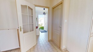 A hallway with a radiator, a door with a window, and a door leading to a balcony. - Villa Good Vibes - Bikes available, large fenced-in garden (Le Fenouiller)
