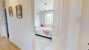 A bedroom with a bed, a window, and a door. - Villa Good Vibes - Bikes available, large fenced-in garden (Le Fenouiller)