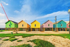 A row of colorful houses with a clear sky. - Bayfront  Home + Balcony | Shared Pool + Pier | Padre Island | Andy's Village (Corpus Christi)