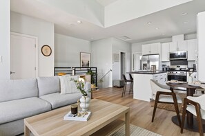 A modern apartment with a living room, kitchen, and dining area. - Sun-Filled Two-Story Home | Near Balboa Park + Gaslamp Quarter | J Street (San Diego)