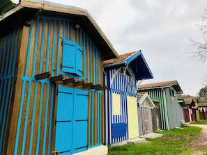 A row of colorful wooden houses with a simple, traditional design. - Charming house - Swimming pool - Bassin Arcachon (Audenge)