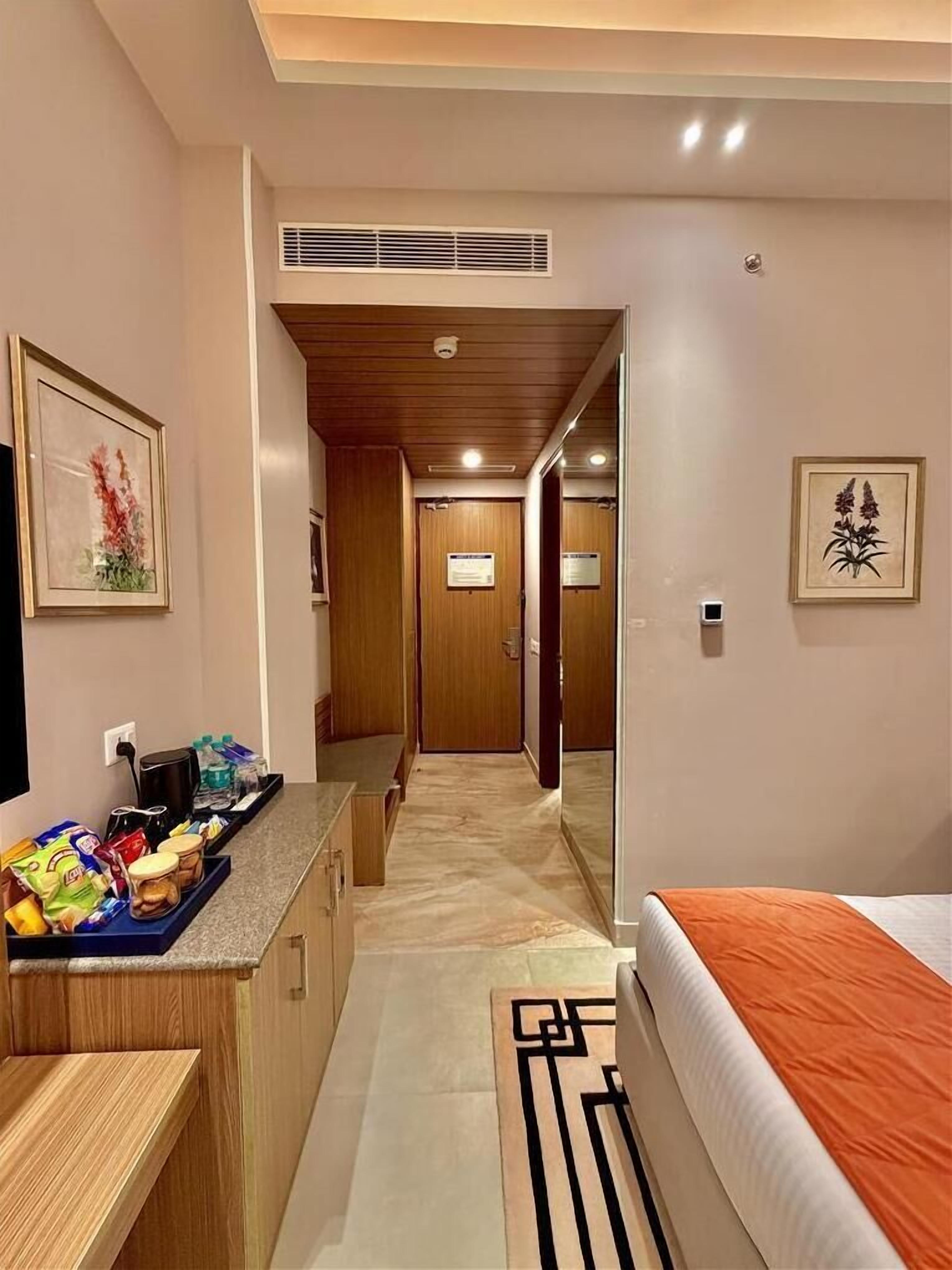Une chambre d’hôtel comprenant un lit, une kitchenette, une salle de bain et un couloir.