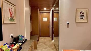 Une chambre d’hôtel comprenant un lit, une kitchenette, une salle de bain et un couloir.