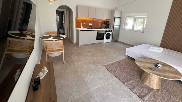 A compact hotel room with a kitchenette, a dining area, and a bed. - Ixia Cozyline Apartment - 106 (Rhodes)