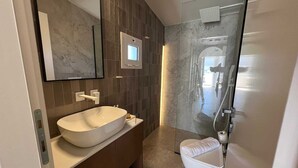 A modern bathroom with a freestanding bathtub, a toilet, and a shower. - Ixia Cozyline Apartment - 106 (Rhodes)