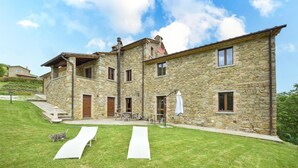 A stone building with a patio, outdoor seating, and a cat on a slide. - Beautiful home in Monte Santa Maria Tibe (Monte Santa Maria Tibe)