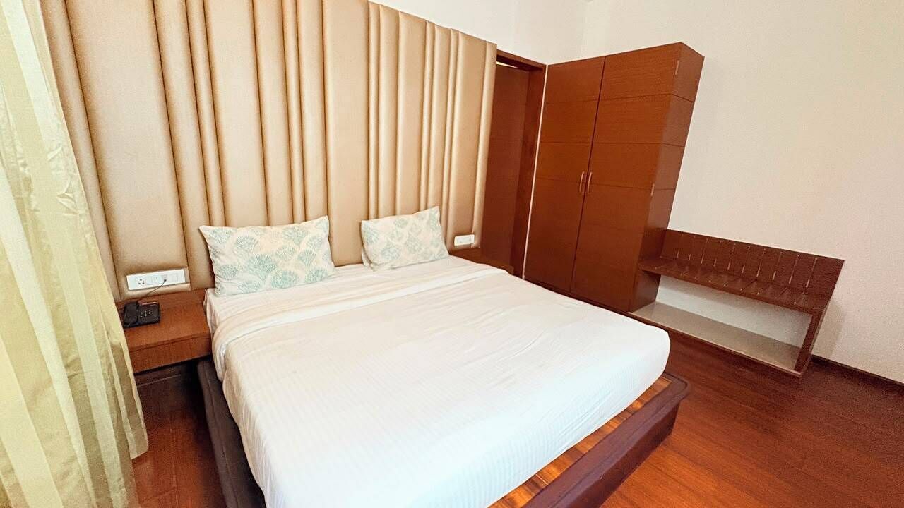 A bedroom with a bed, bedside tables, a wardrobe, and a bench.