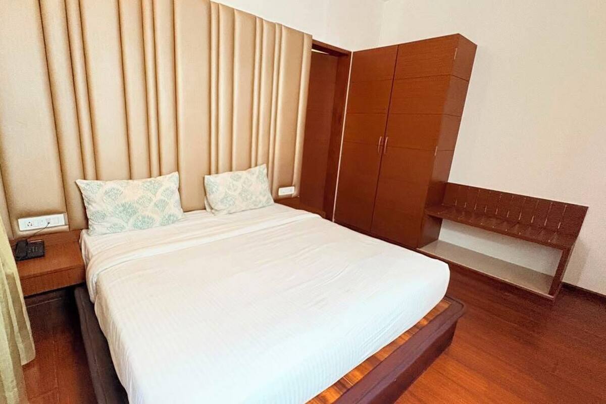 A bedroom with a bed, bedside tables, a wardrobe, and a bench.