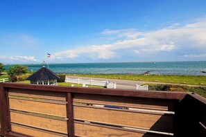 A view of a coastal area with a gazebo, a flagpole, and a clear sky.