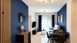 A modern living room with a sofa, dining table, and TV. - Apartment for 3, a short walk from the beaches (Roquetas de Mar)
