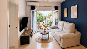 A living room with a sofa, TV, and a round coffee table. - Apartment for 3, a short walk from the beaches (Roquetas de Mar)