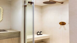 A modern bathroom with a glass shower enclosure, a wooden vanity, and a minimalist design. - 1BDR/4P flat with stunning sea views (Antibes)