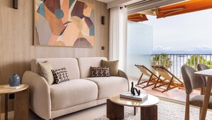 A modern living room with a sofa, coffee table, and artwork on the wall. - 1BDR/4P flat with stunning sea views (Antibes)