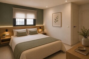 Ein Schlafzimmer mit Bett, Nachttischen, Fenster mit Jalousien, einem gerahmten Bild an der Wand und einer Tür.