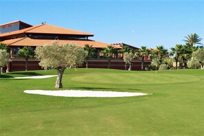 A golf course with a building in the background. - Max Apartment with communal garden and pool (Roquetas de Mar)