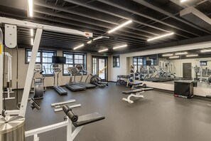 Ein modernes Fitnessstudio mit Laufbändern, Crosstrainern und Gewichtsmaschinen.