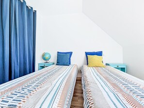 A bedroom with two beds, a globe on a nightstand, and a window with curtains. - Maison de Kermamas by Interhome (Sarzeau)
