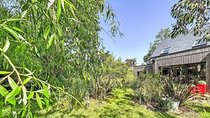 A garden with various plants and a wooden house with a glass door. - Maison de Kermamas by Interhome (Sarzeau)