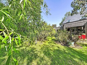 A garden with various plants and a wooden house with a glass door. - Maison de Kermamas by Interhome (Sarzeau)