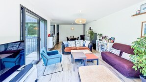 A modern living room with a sofa, chairs, a coffee table, and a TV. - Maison de Kermamas by Interhome (Sarzeau)