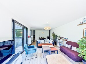 A modern living room with a sofa, chairs, a coffee table, and a TV. - Maison de Kermamas by Interhome (Sarzeau)