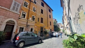 A narrow cobblestone street lined with multi-story buildings, some with visible graffiti. - Apartment in Rome with 0 bedrooms sleeps 2 (Rome)