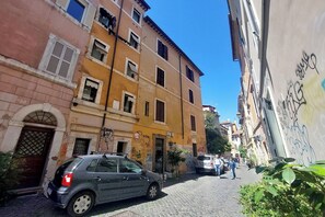 A narrow cobblestone street lined with multi-story buildings, some with visible graffiti. - Apartment in Rome with 0 bedrooms sleeps 2 (Rome)
