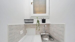 A compact kitchen with a sink, a window above, and a potted plant. - Apartment in Rome with 0 bedrooms sleeps 2 (Rome)