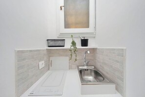 A compact kitchen with a sink, a window above, and a potted plant. - Apartment in Rome with 0 bedrooms sleeps 2 (Rome)