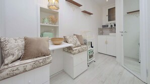 A compact kitchen with white cabinetry, a built-in oven, and a hanging light fixture. - Apartment in Rome with 0 bedrooms sleeps 2 (Rome)