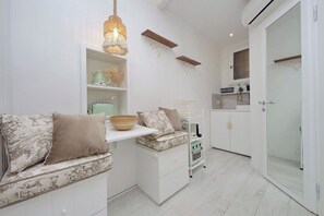 A compact kitchen with white cabinetry, a built-in oven, and a hanging light fixture. - Apartment in Rome with 0 bedrooms sleeps 2 (Rome)
