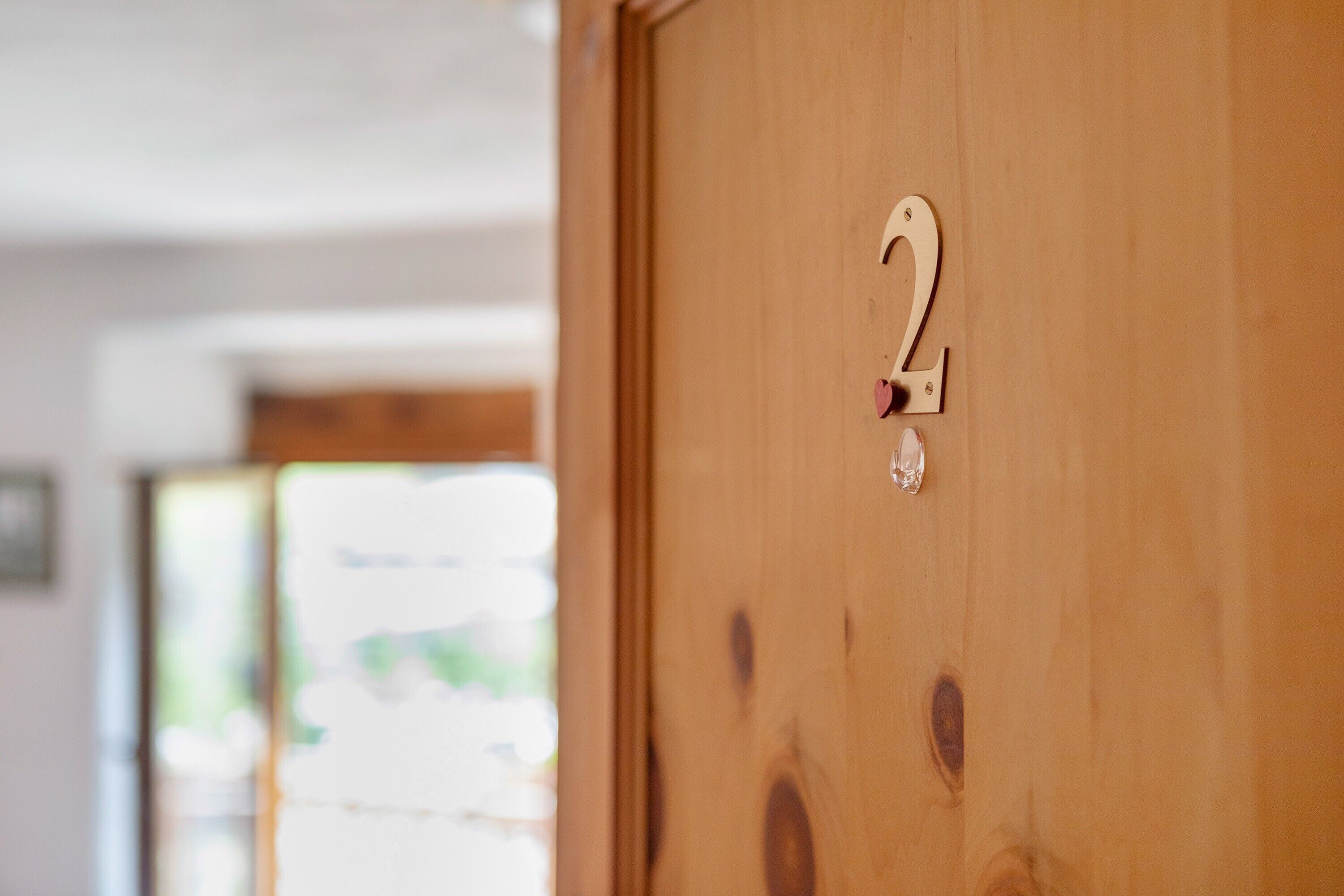 Une porte en bois avec une plaque portant le numéro « 2 ».