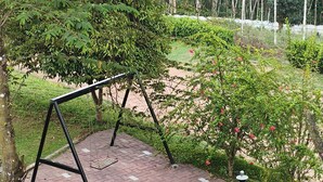 A playground with swings and a seesaw. - Wayanad Cave N Pillar Resort (Krishnagiri)