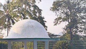 A clear blue pool with a white dome structure and a pavilion. - Wayanad Cave N Pillar Resort (Krishnagiri)