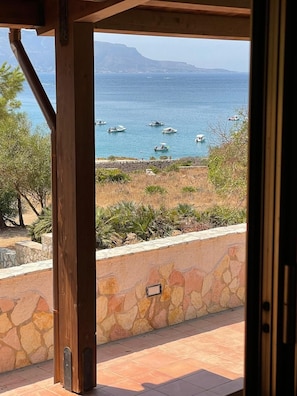 A stone wall with a view of the sea and boats.