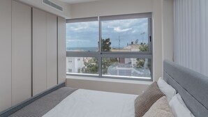 A bedroom with a large window, a bed, and a wardrobe. - Sea View Riviera Maisonette with Large Terraces (Voula)