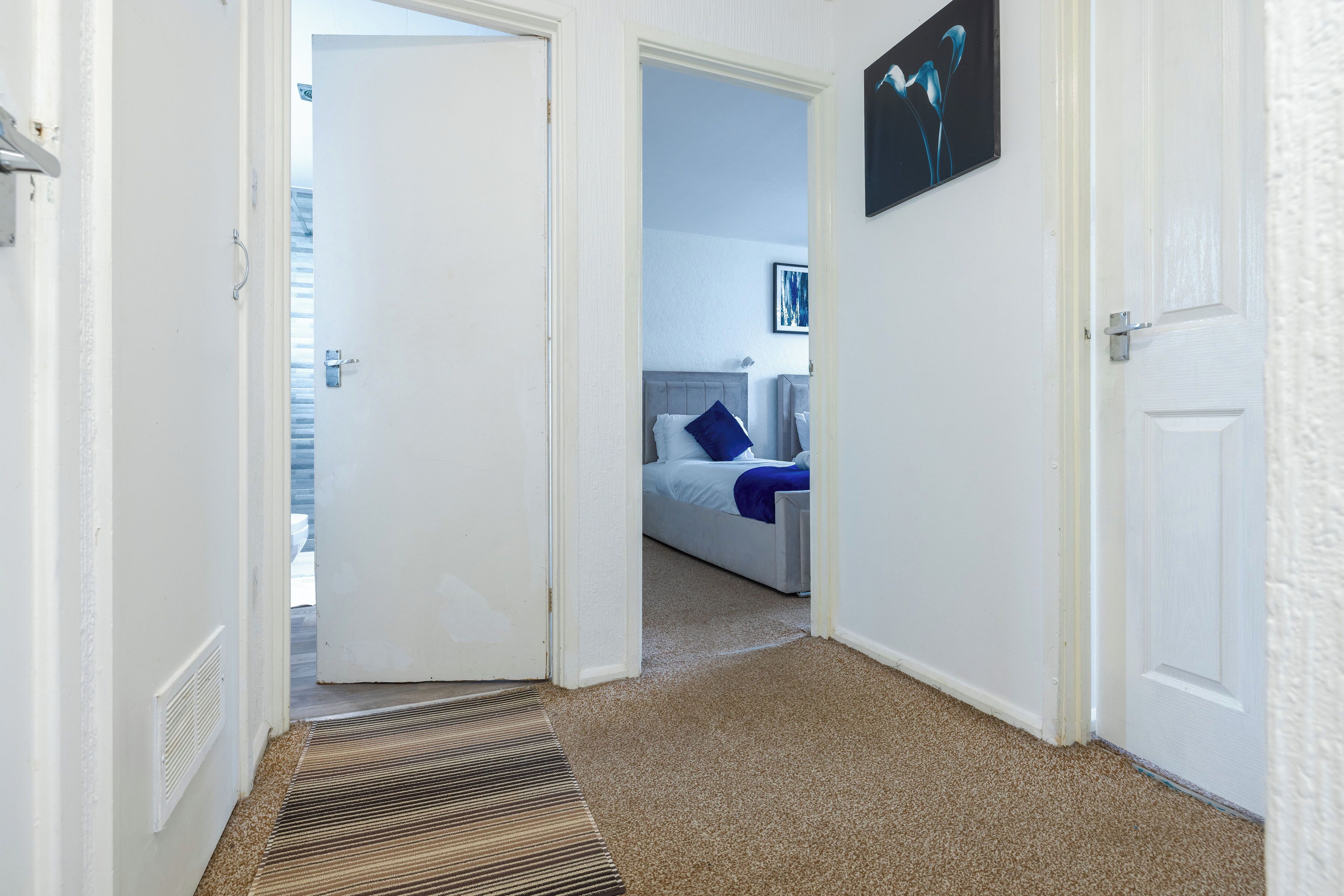 Habitación de hotel con cama, un cuadro y vista al exterior.