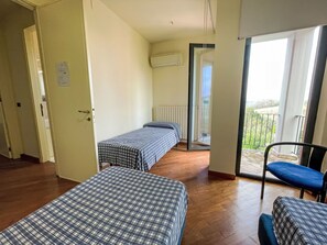A room with two beds, a chair, a radiator, and a balcony with a view. - Vacation home Vidal by Interhome (Spoltore)